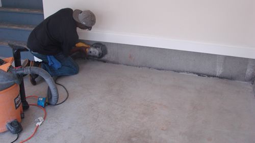 Grolar Sealants Employee Sanding wall before sealing with Grolar Sealants Product